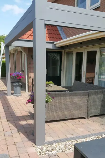 Nomo tuinkamer met schuifdak en zithoek op betegeld terras bij woning Nomo tuinkamer met schuifdak en zithoek op betegeld terras bij woning