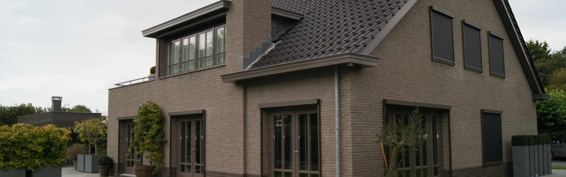 Voorzijde van woning met zonwerende screens Voorzijde van woning met zonwerende screens