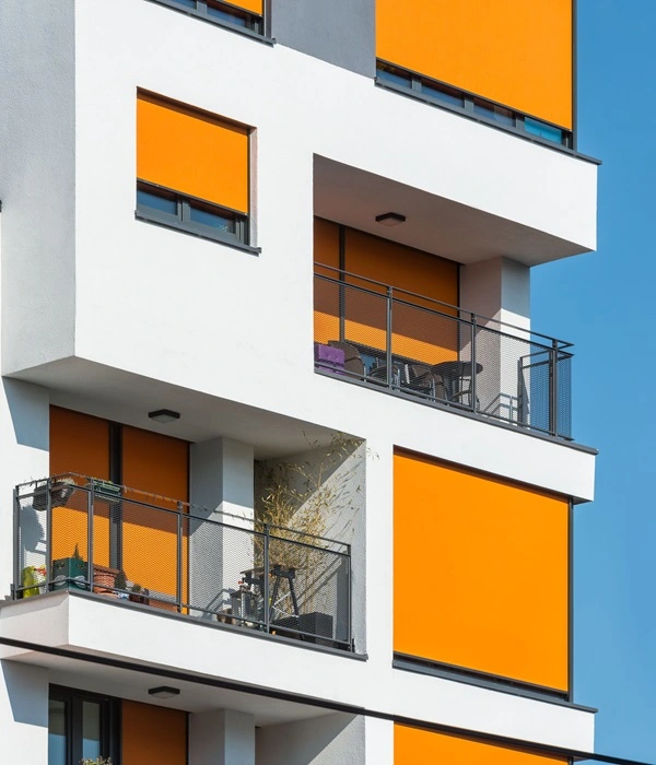 Appartementengebouw met opvallende oranje screens op meerdere verdiepingen