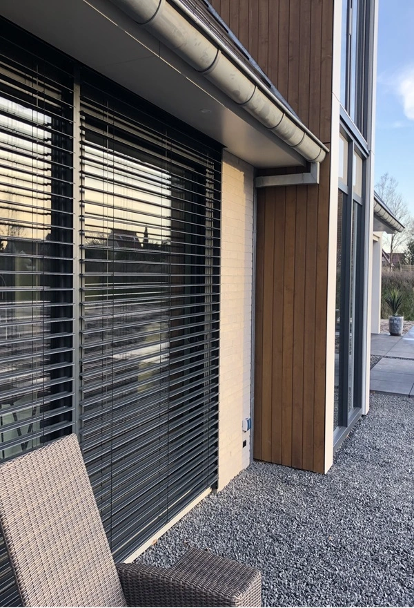Buitenjaloezie met zitstoelen op grindterras bij woning in Joure Buitenjaloezie met zitstoelen op grindterras bij woning in Joure