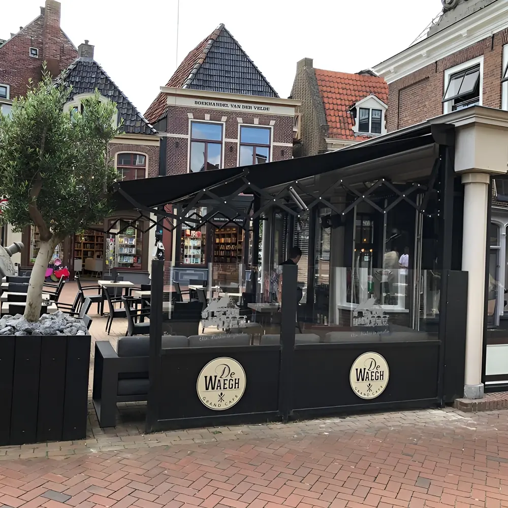Buitenruimte met schaararmscherm en branding van Grand Cafe De Waag