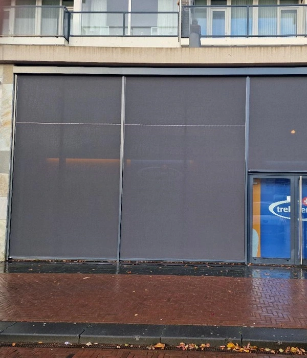 Donkere zip screens voor een winkelgevel in Drachten