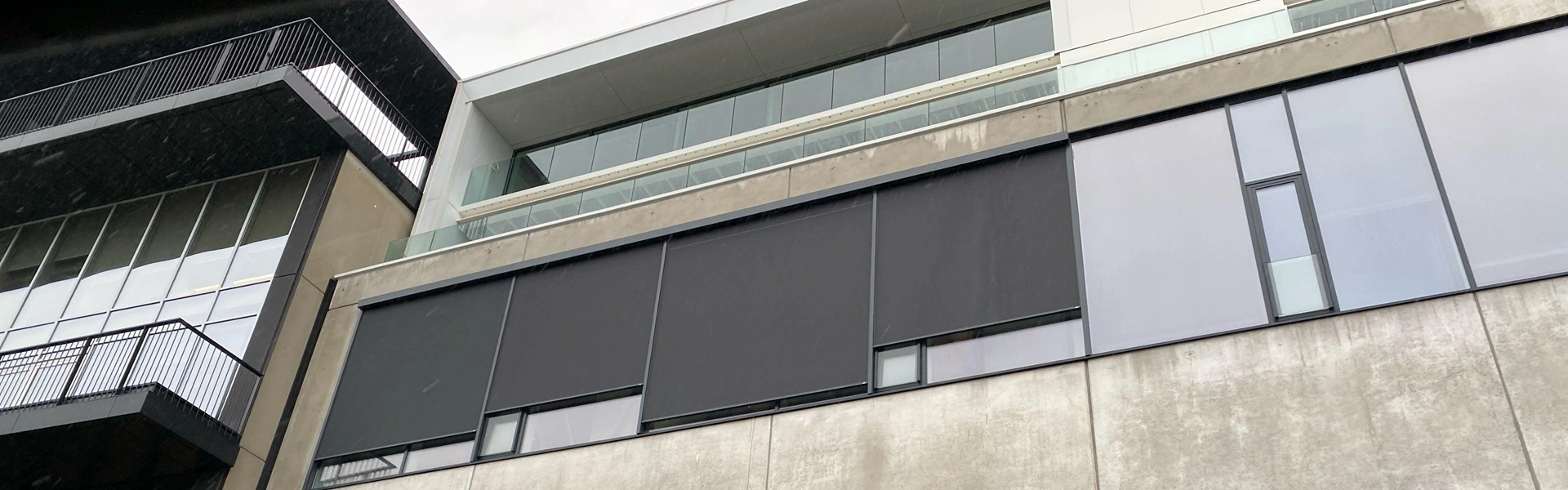 Geluidsstudio met strakke zwarte zonwering en glazen elementen