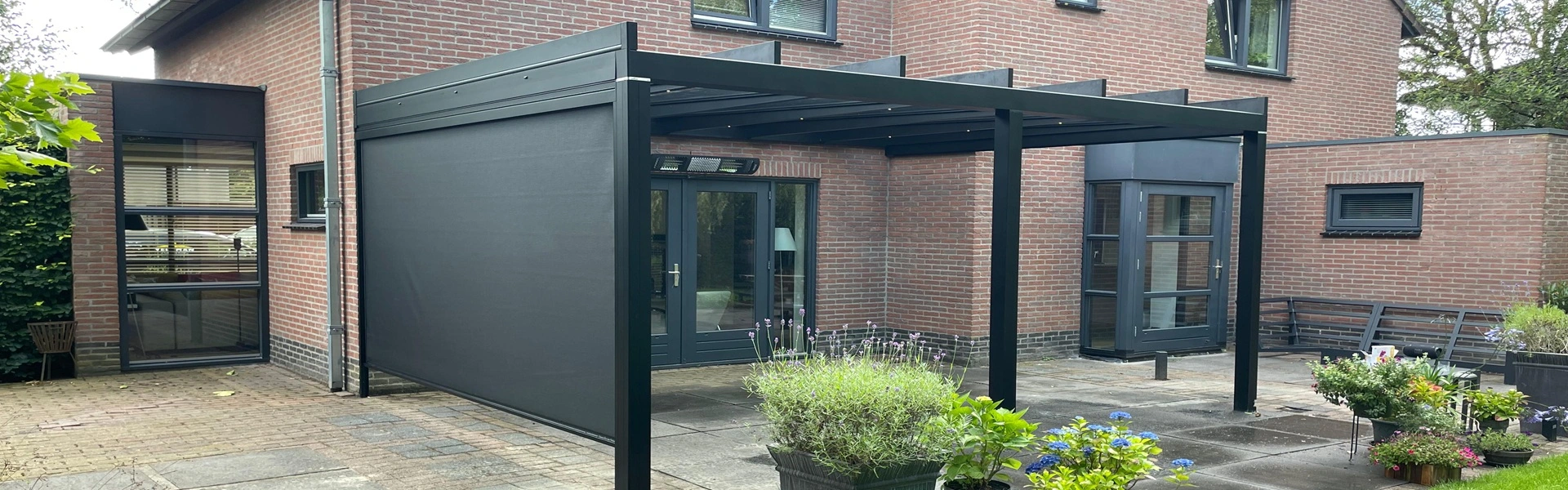 Glazen overkapping aan een bakstenen huis, ideaal voor buitencomfort