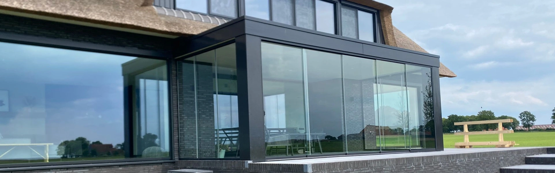 Glazen uitbouw met schuifwanden en ruim uitzicht op het landschap in Oudemirdum Glazen uitbouw met schuifwanden en ruim uitzicht op het landschap in Oudemirdum