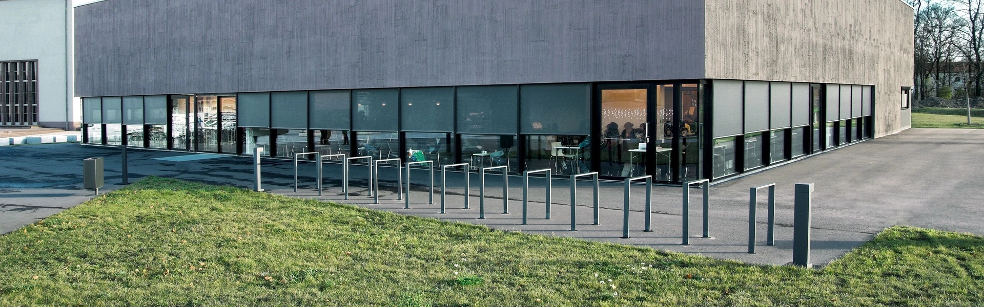 Grijs kantoor met buitenzonwering screens en groene omgeving