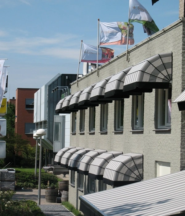 Grijze gestreepte markiezen boven ramen van kantoorpand