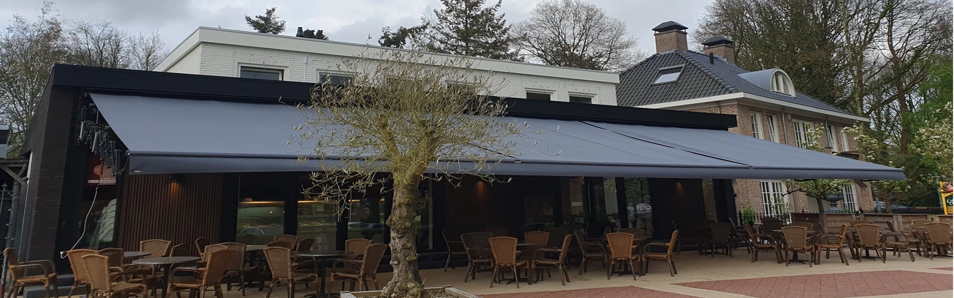 Groot schaararmscherm XXL over terras biedt effectieve zonwering en beschutting