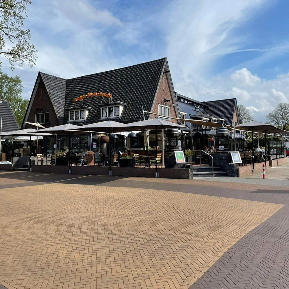 Grote parasols bedekken een ruim horecaterras in landelijke stijl