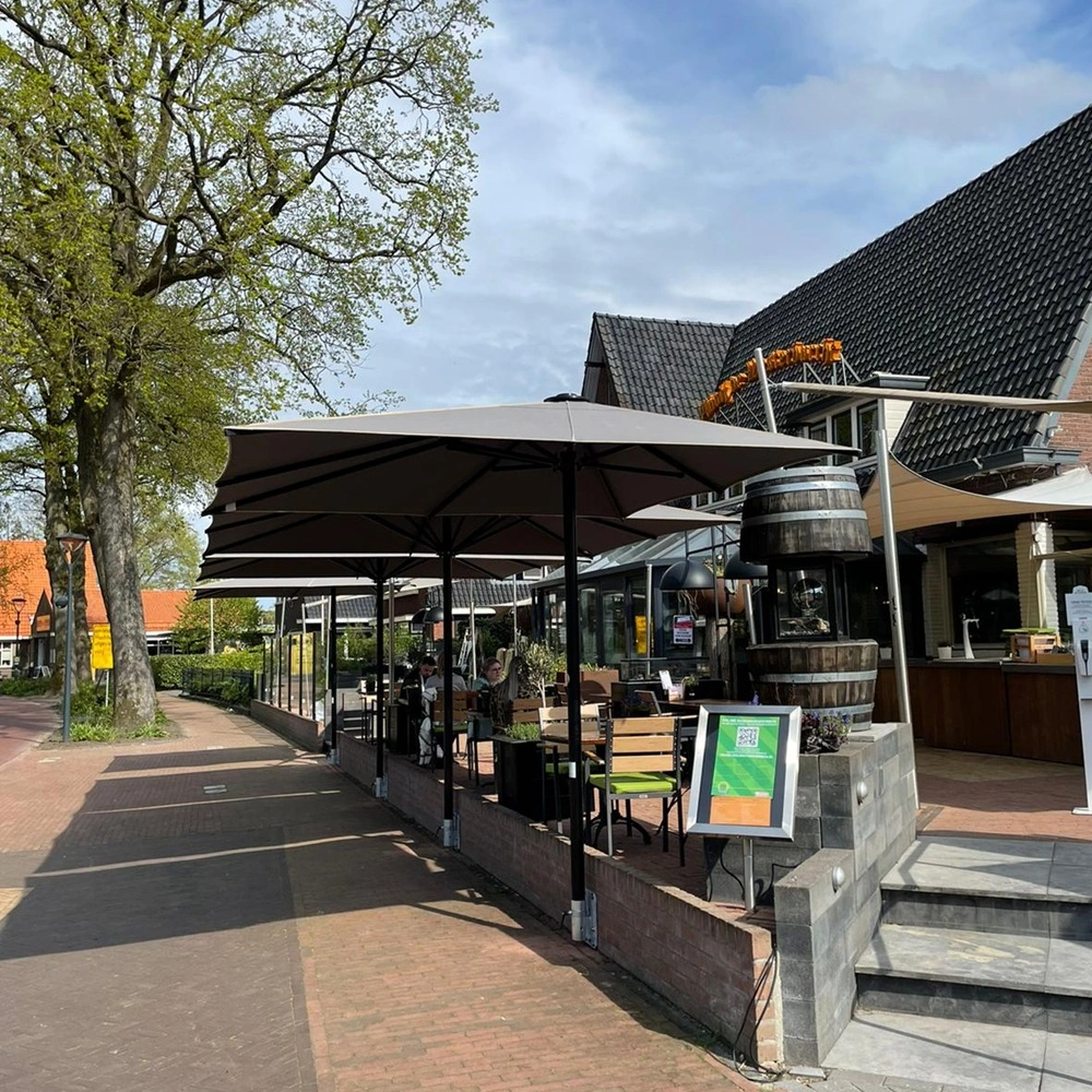 Grote parasols voor schaduw op zonnig terras bij restaurantentree