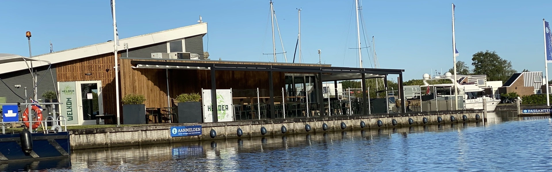 Horeca overkapping met glazen schuifpanelen en uitzicht op het meer