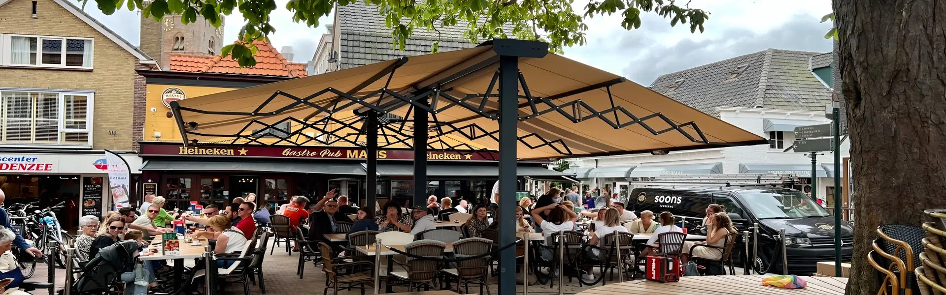 Horeca terras met schaararmscherm Vertigo onder schaduwrijke bomen