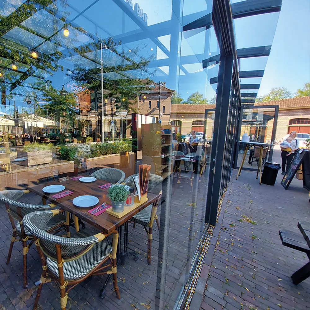 Horecaterras met glazen schuifwanden en sfeervolle inrichting