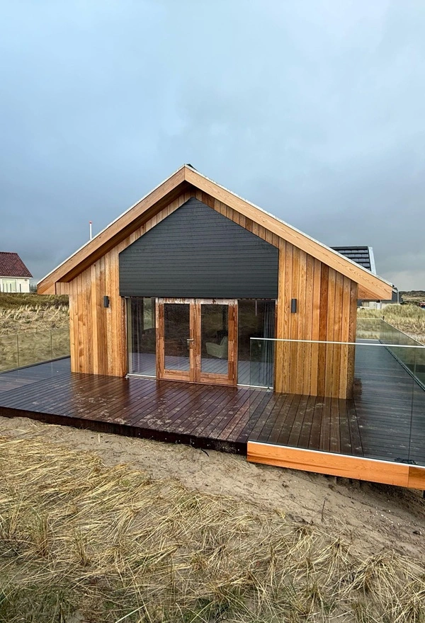 Houten villa met louvre lamellen van Veldman Zonwering op Terschelling Houten villa met louvre lamellen van Veldman Zonwering op Terschelling