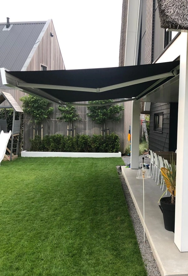 Knikarmscherm boven terras met grasveld Knikarmscherm boven terras met grasveld