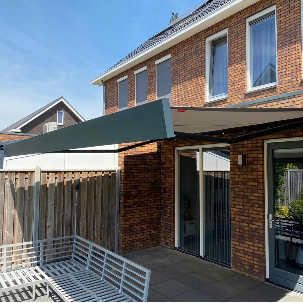 Knikarmscherm boven terras met houten schutting Knikarmscherm boven terras met houten schutting