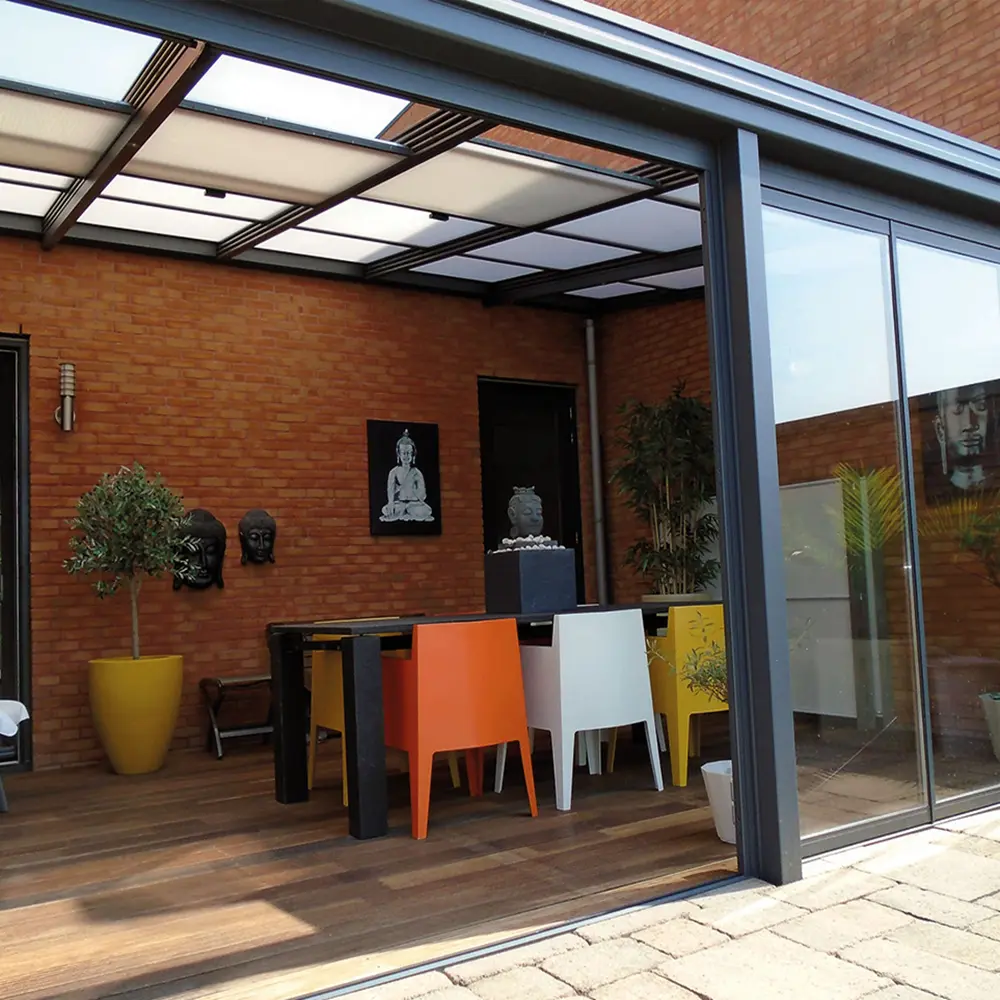 Lichtovergoten terrasoverkapping met moderne inrichting en schuifdeuren
