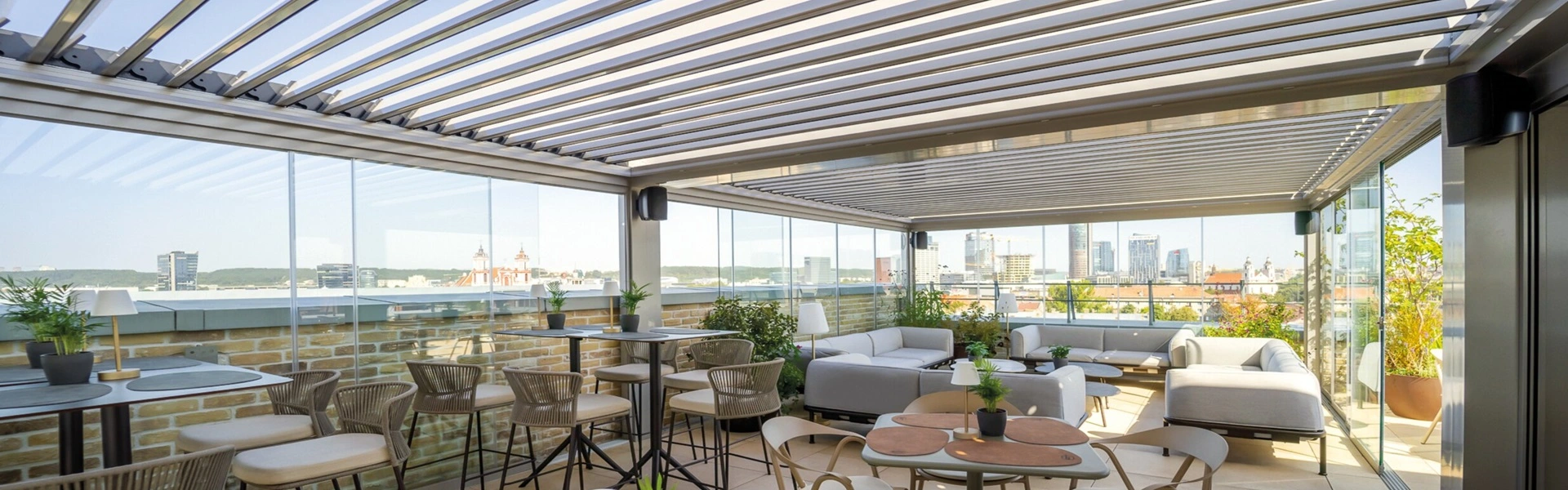 Luxe bar met zitgedeelte onder een lamellenoverkapping op rooftop