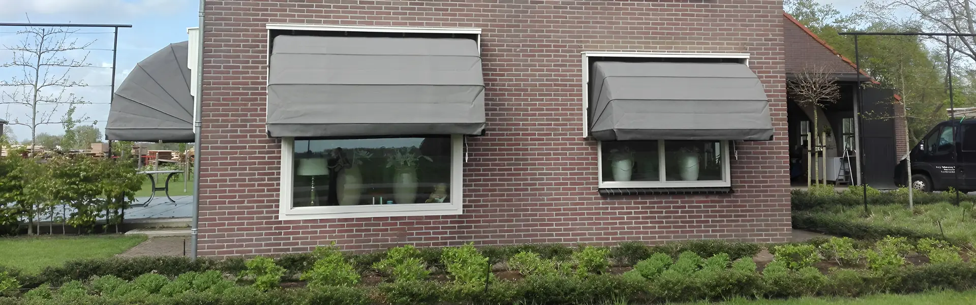 Markiezen in neutrale tint aan zijgevel van huis in Donkerbroek Markiezen in neutrale tint aan zijgevel van huis in Donkerbroek