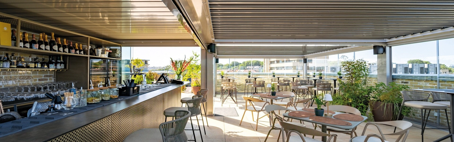 Moderne bar met tafels en glazen schuifwanden op dakterras