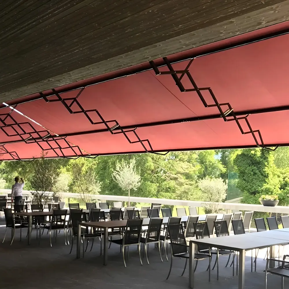 Overdekt horecaterras met rood schaararmscherm, geschikt voor groepen