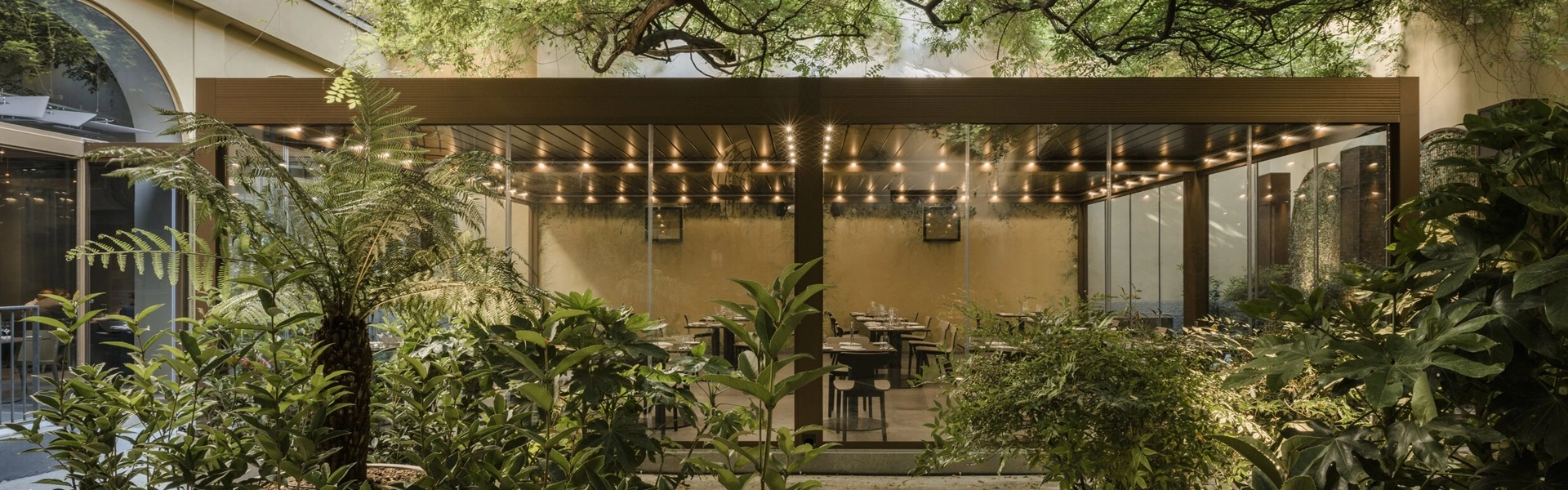 Overkapping in een groene setting met sfeervolle verlichting