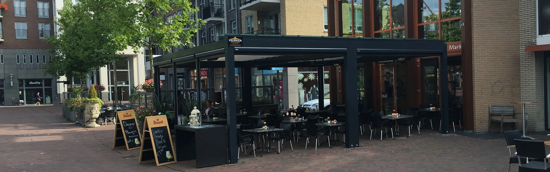 Overkapping met glazen wanden en schuifdak op een horecaterras