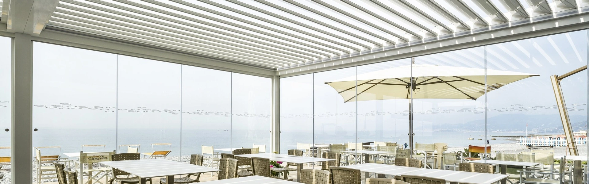 Overkapping met lamellen bij een horeca gelegenheid met zeezicht