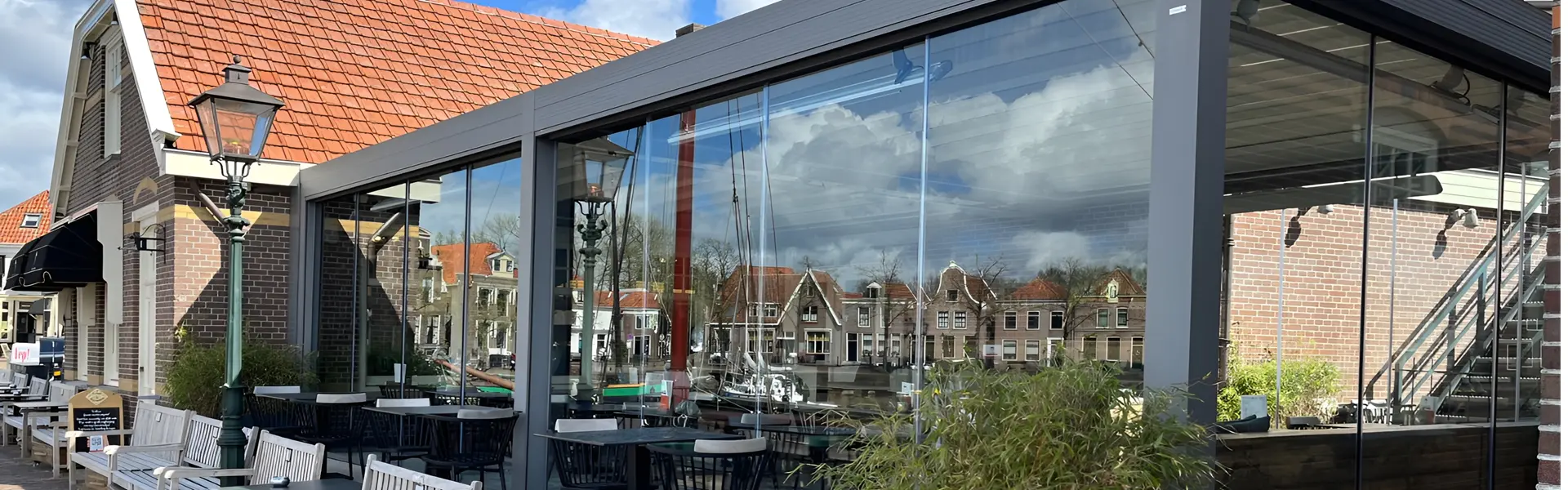 Overkapping met verlichting en terrasmeubilair bij een horecagelegenheid