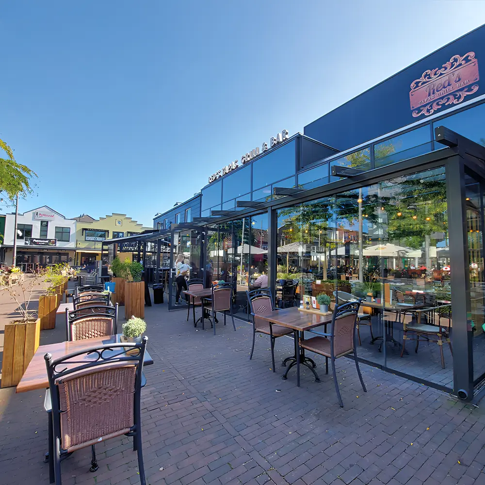 Restaurant met glazen overkapping en buitenzitplaatsen
