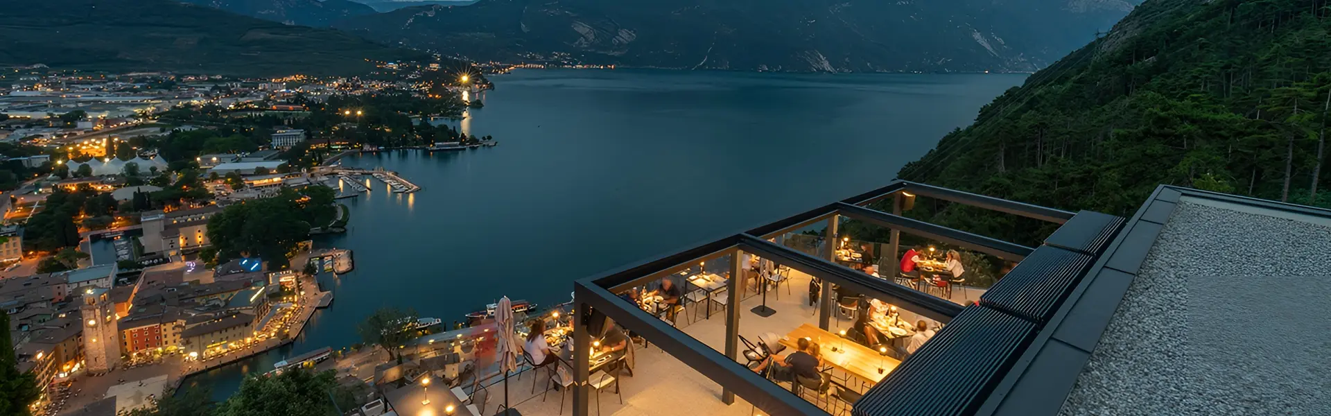 Restaurantterras met uitzicht over een meer en verstelbare lamellen