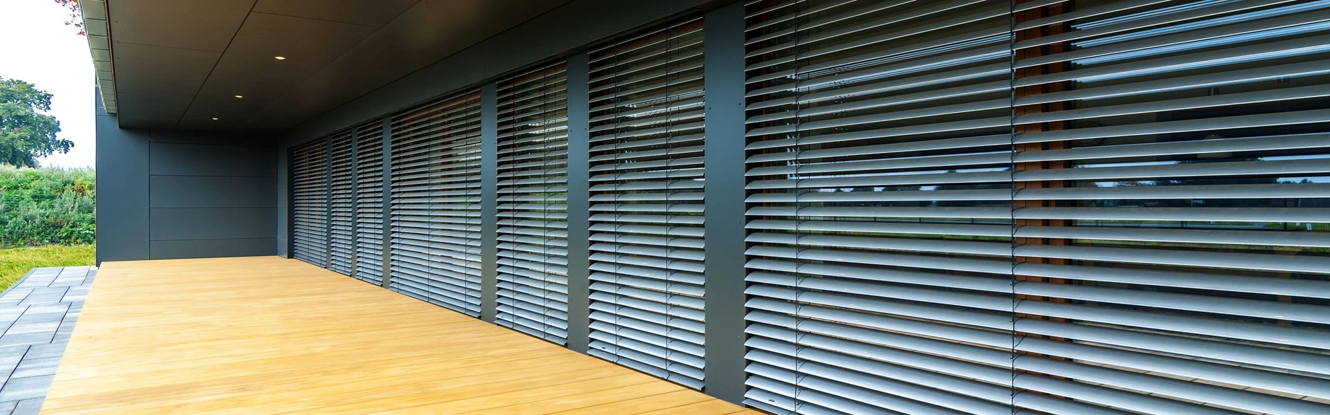 Rolluiken die zorgen voor privacy en schaduw in een showroomruimte