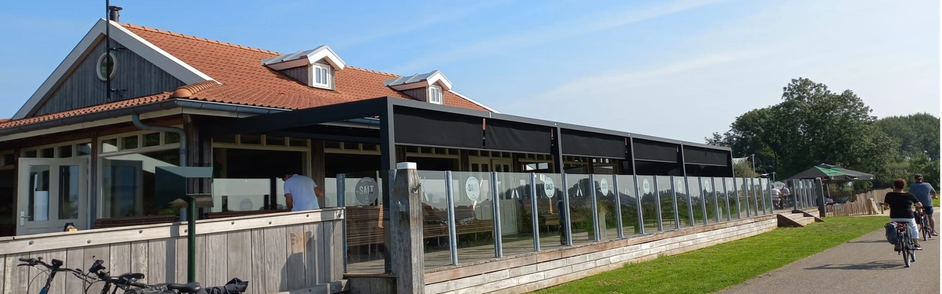 Salt restaurant met overkapping en windschermen langs een fietspad
