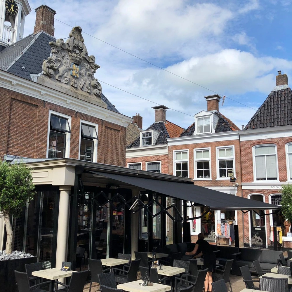 Schaararmscherm in klassieke straat met terras bij historisch gebouw