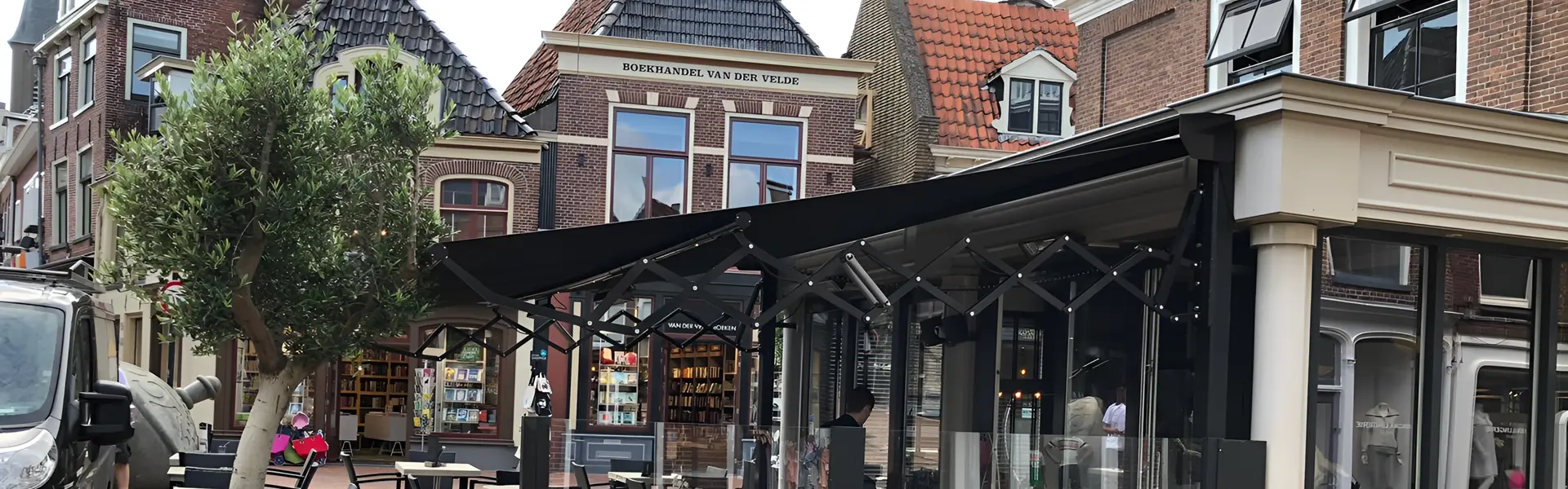 Schaararmscherm met strak doek bij horecapand in historisch centrum