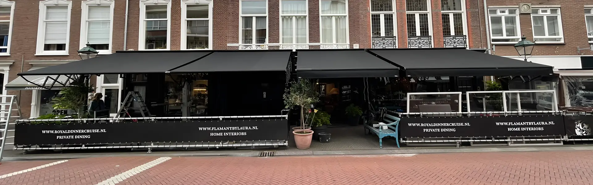 Schaararmscherm mini biedt schaduw aan restaurant met buitenzitplaatsen