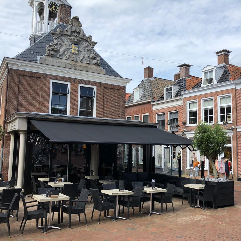 Schaararmscherm op terras van historisch gebouw, zon- en regenwering voor horeca