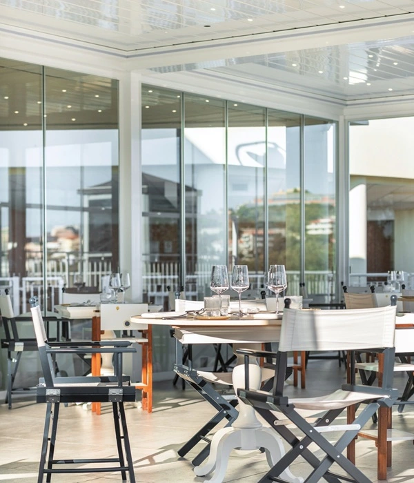 Sfeervolle horeca-overkapping met glazenwanden en accessoires