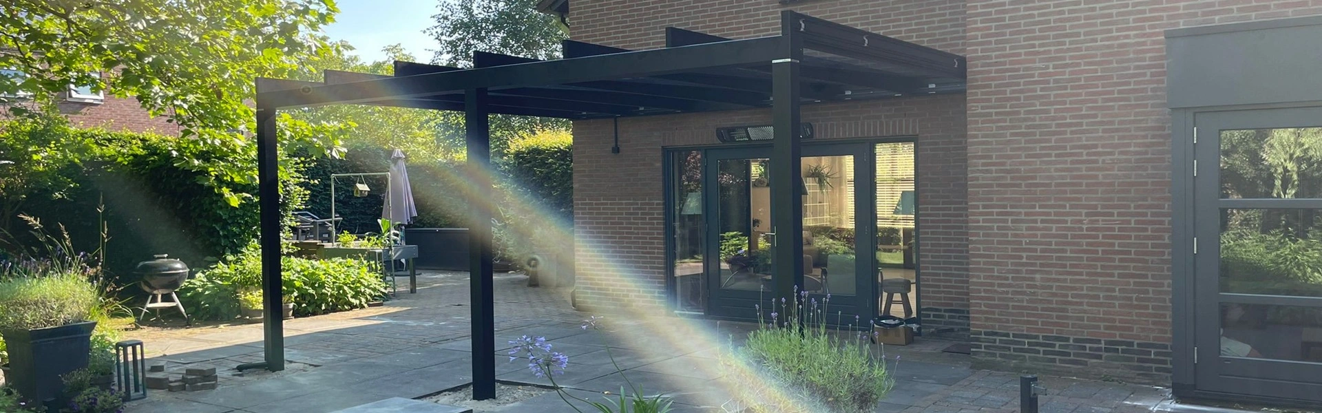 Strakke glazen overkapping met zijwand en decoratieve planten