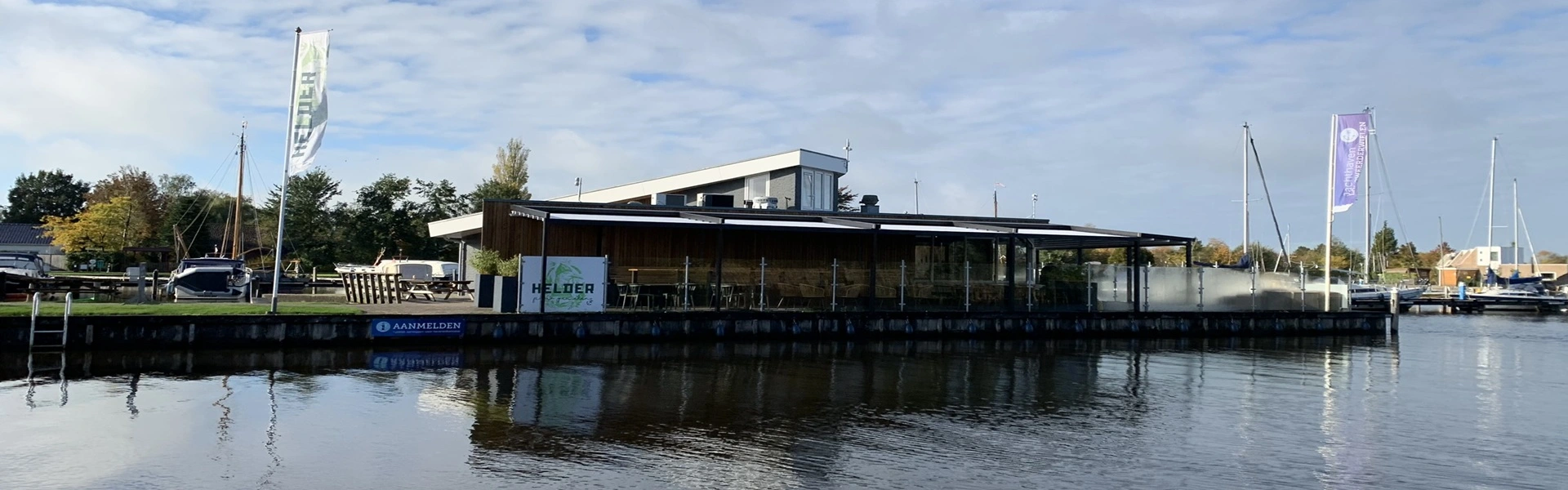 Terras met overkapping aan het water bij Helder beschermd tegen regen en zon