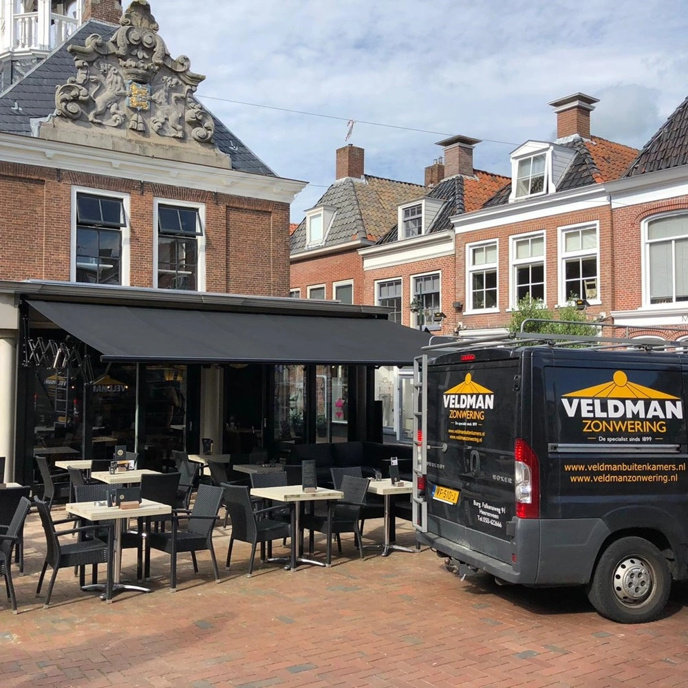 Veldman Zonwering bus naast terras met schaararmscherm historische omgeving