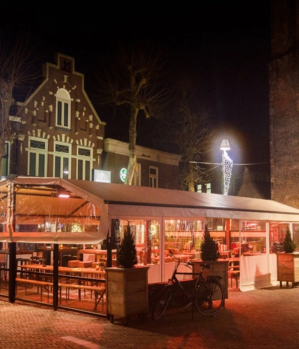 Verlichte loungebar met transparante zijwanden en verwarmd terras Verlichte loungebar met transparante zijwanden en verwarmd terras