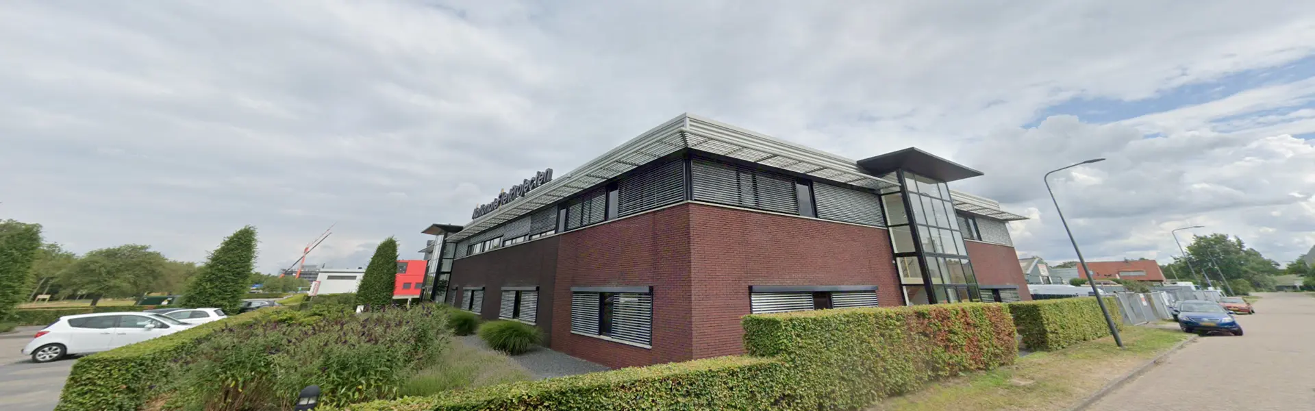 Voorgevel van bedrijfspand met jaloezieen en bakstenen gevel