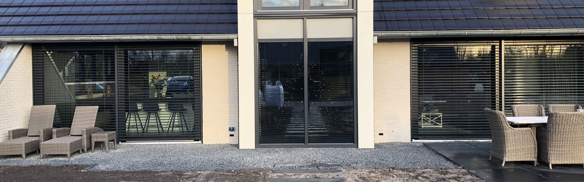 Voorzijde van een woning in Joure met buitenjaloezie en een terras met zitgedeelte Voorzijde van een woning in Joure met buitenjaloezie en een terras met zitgedeelte