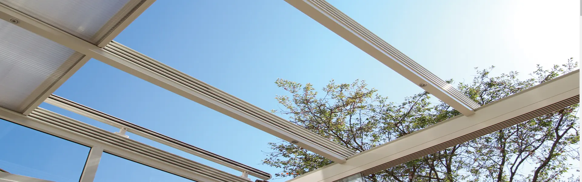 Witte polycarbonaat overkapping met schuifdak en blauwe lucht