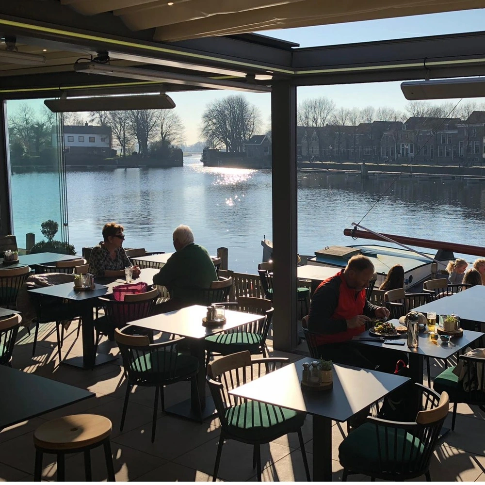 Zonovergoten terras met glazen wanden en een schuifdak