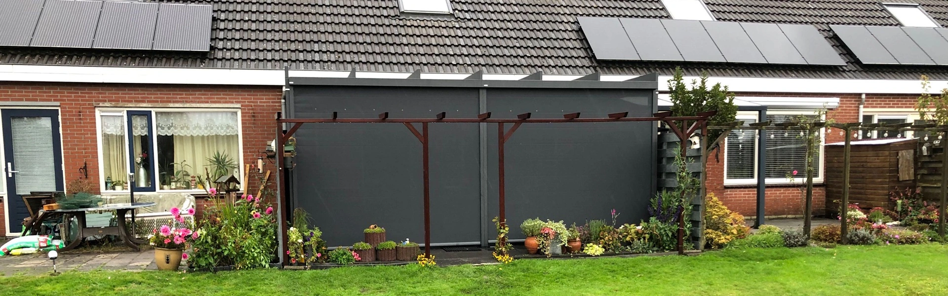 Achtergevel met tuinkamer Terrazza Pure en kleurrijke tuin