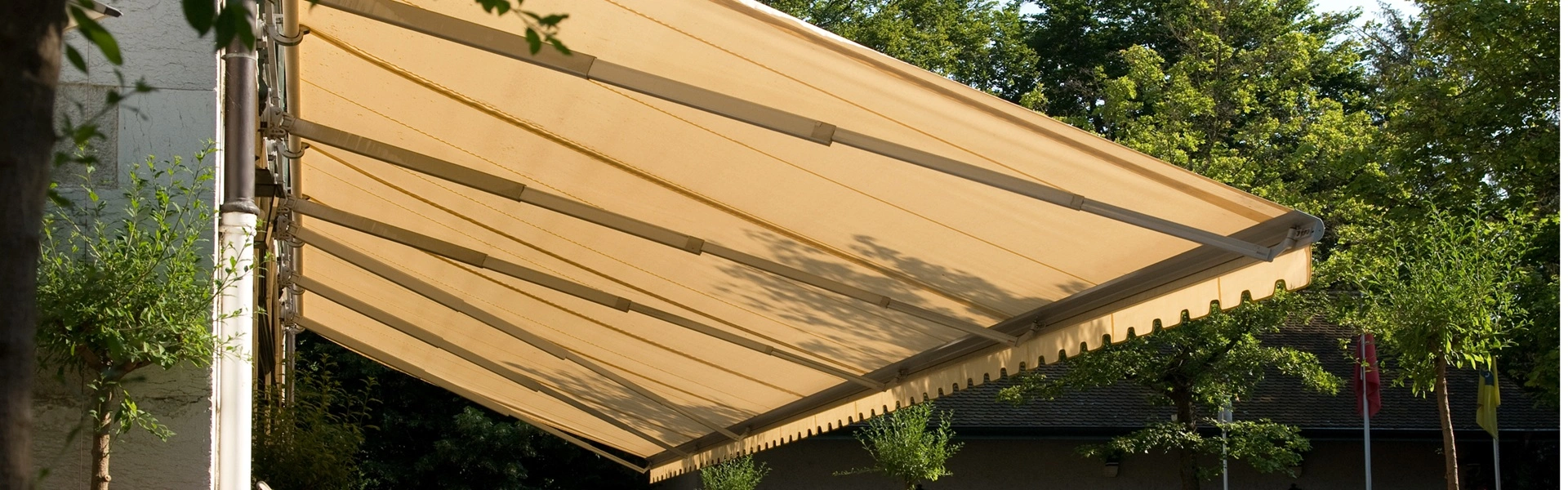 Beige knikarmscherm Jumbo boven terras