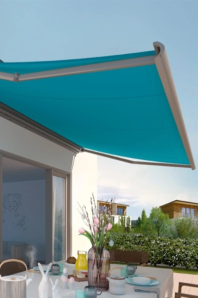 Blauw knikarmscherm Cassita boven terras met tuintafel Blauw knikarmscherm Cassita boven terras met tuintafel