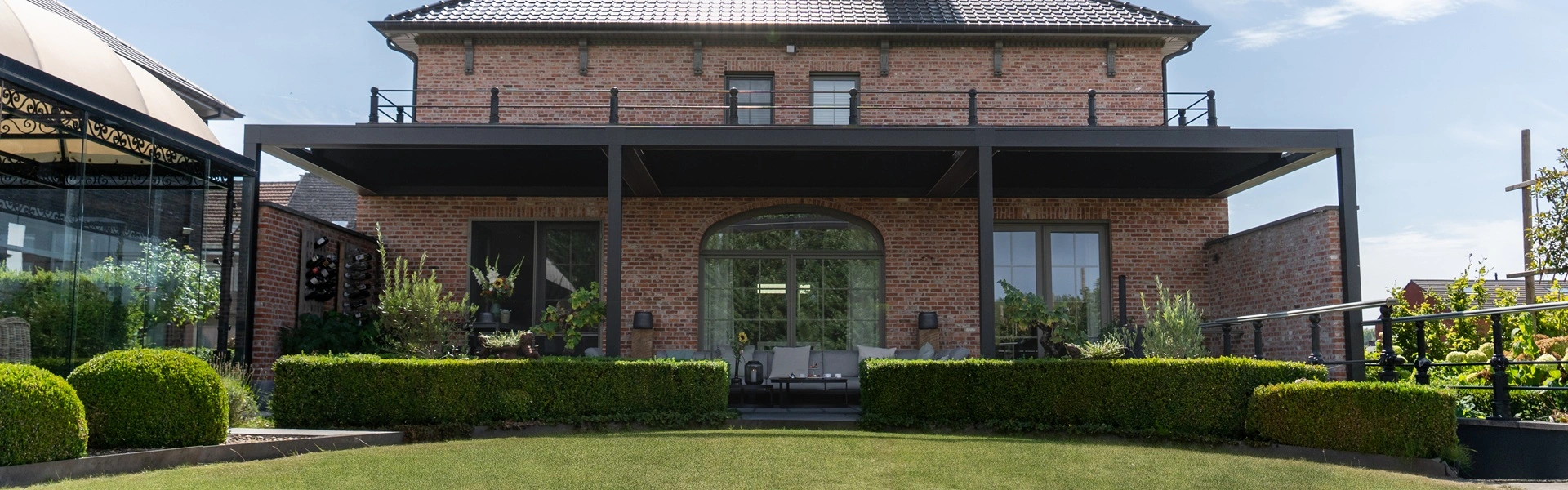 Brera lamellenoverkapping achter een huis met klassieke bakstenen gevel